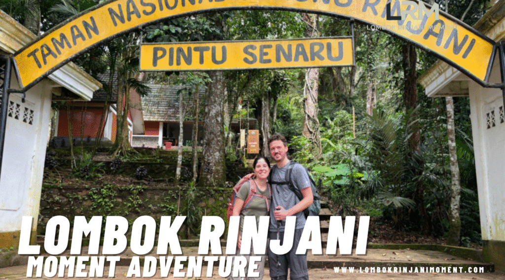 A smiling couple of hikers under the "Taman Nasional Gunung Rinjani - Pintu Senaru" gate, surrounded by dense green forest, marking the start or end of the trek.