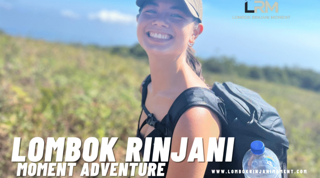 A young female hiker smiling brightly and wearing a cap and backpack on a sunny, grassy slope of Mount Rinjani.