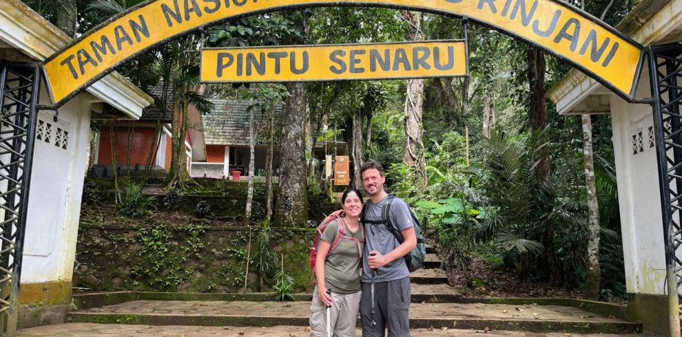 A couple stands in front of the Senaru entrance to Gunung Rinjani National Park.